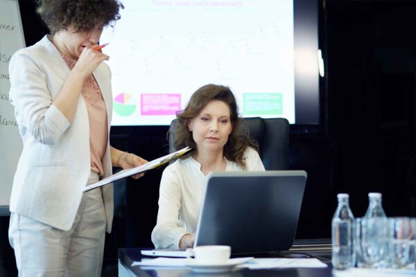 secretary of state case study image woman sitting looking at laptop with woman standing beside her looking at laptop