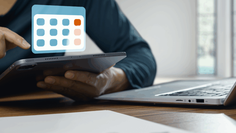 Person-sitting-desk-laptop-looking-calendar-on-tablet-ReFrame-Solutions-Business-Services-Blog-Hero